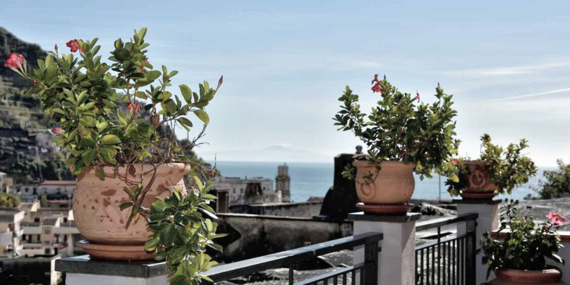 Terrasse fleurie à Minori avec vue imprenable sur la mer et la Côte Amalfitaine.