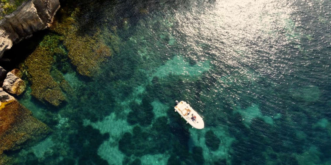Vue aérienne d'un bateau sur les eaux cristallines lors d'une excursion à Procida.