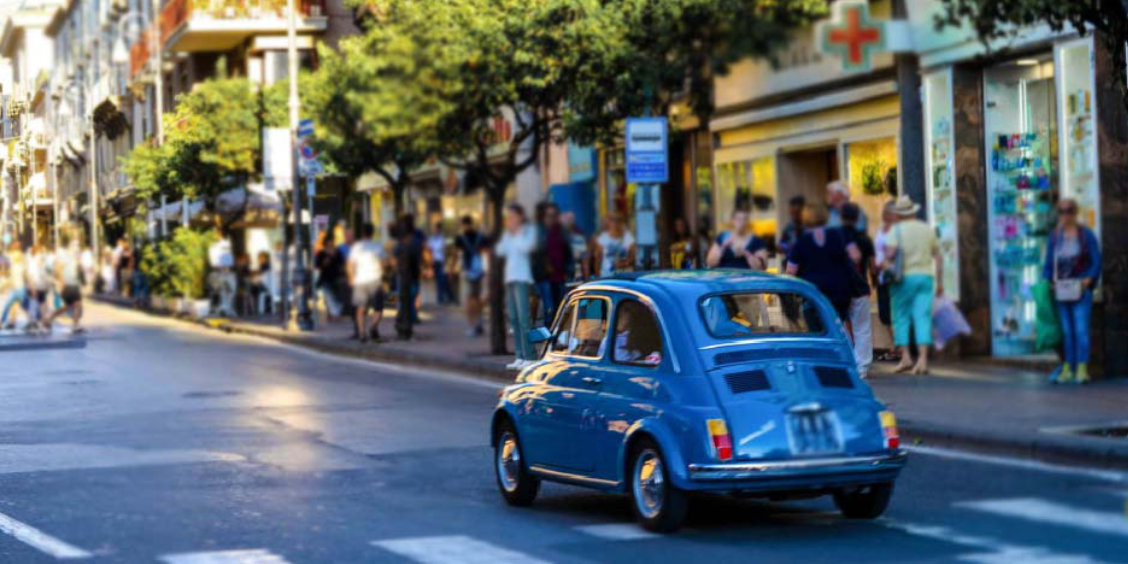 Voiture dans une rue animée de Sorrente près des commerces.
