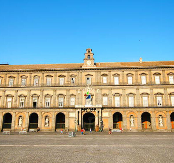 Palais Royal de Naples sur la Piazza del Plebiscito, avec façade monumentale, arcades et statues historiques.