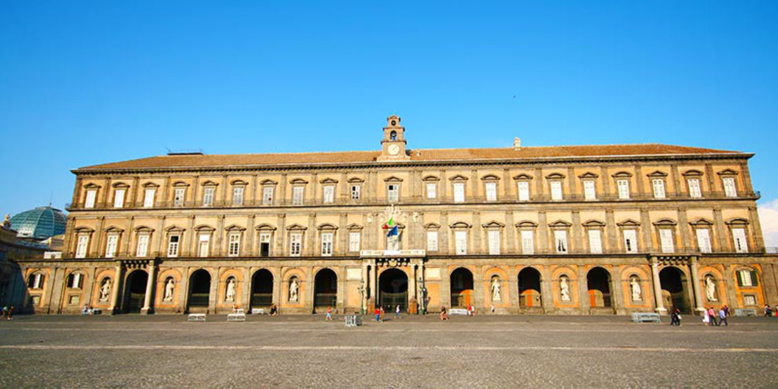 Palais Royal de Naples sur la Piazza del Plebiscito, avec façade monumentale, arcades et statues historiques.