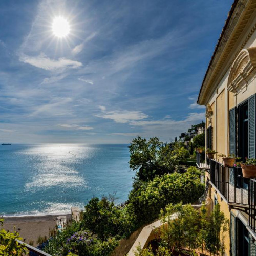 Façade du Palazzo Suriano à Vietri sul Mare avec balcon et vue panoramique sur la mer.