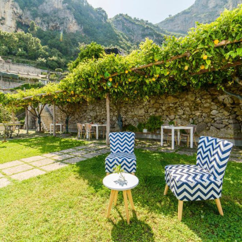 Jardin du Pesce d’Oro à Amalfi avec citronniers, fauteuils et montagnes.