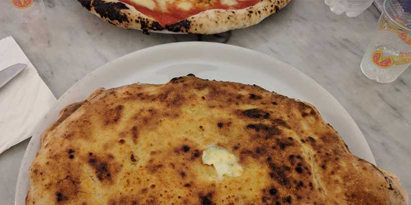 Calzone sans gluten doré servi à Naples, spécialité italienne dans une pizzeria napolitaine.