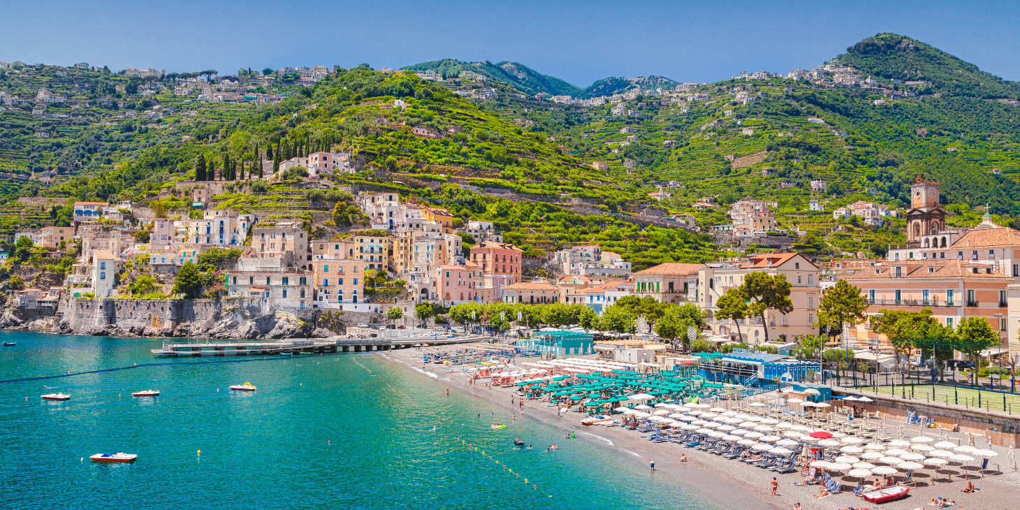 Plage de Minori avec ses nombreux parasols colorés au pied des collines de la Côte Amalfitaine.