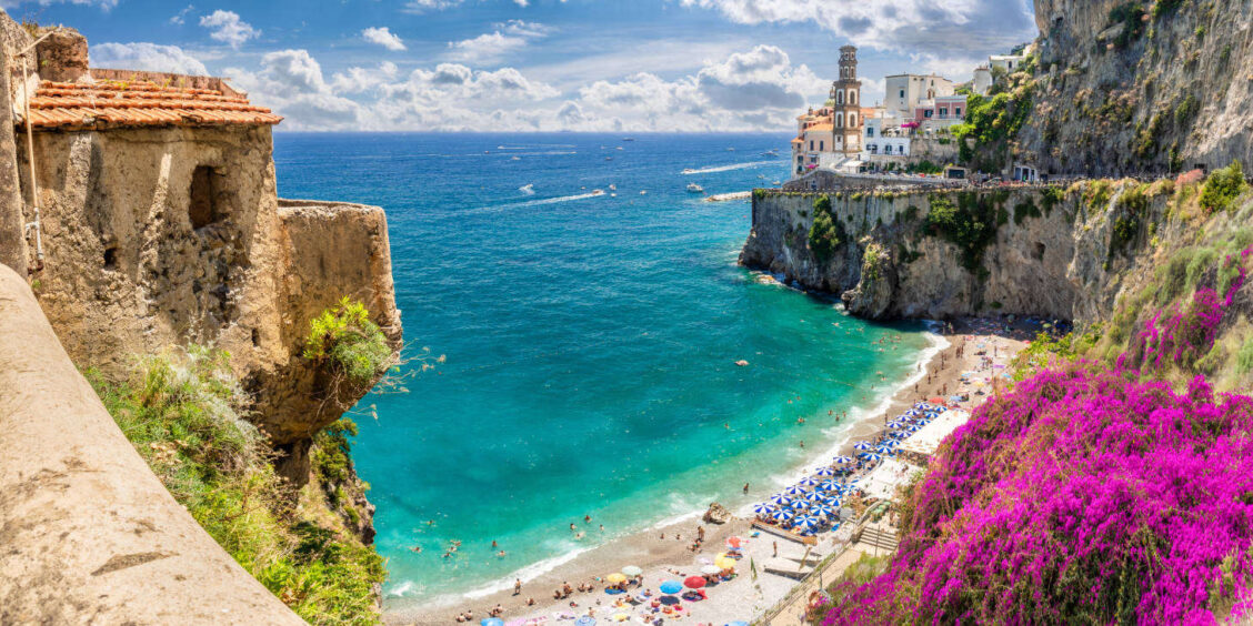 Vue panoramique de la plage de Castiglione à Ravello sur la Côte Amalfitaine, avec ses eaux turquoise et ses falaises fleuries.