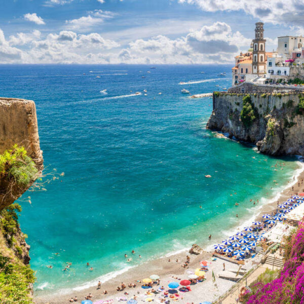 Vue panoramique de la plage de Castiglione à Ravello sur la Côte Amalfitaine, avec ses eaux turquoise et ses falaises fleuries.