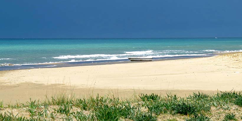 Plage de Paestum en Campanie, avec sable clair, mer turquoise et horizon bleu.