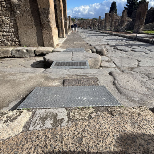 Dispositifs métalliques recouvrant les pierres de passage pour rendre les rues de Pompéi accessibles à tous.