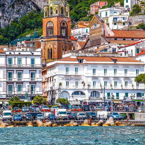 Vue d’Amalfi depuis la mer avec la cathédrale et les maisons au pied de la montagne.