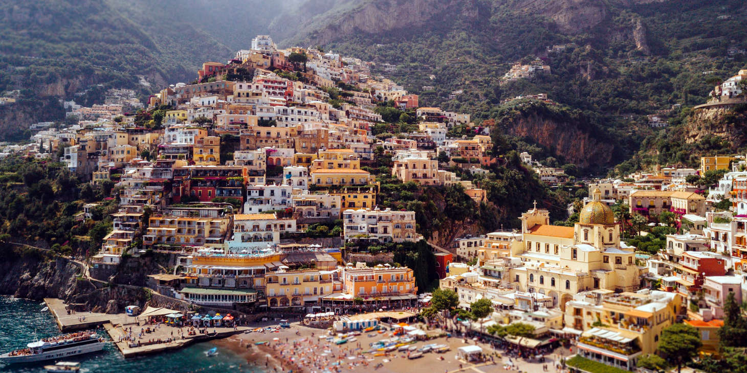 Littoral de Positano, le village vertical d'Italie, avec ses architectures méditerranéennes et son église a dôme doré surplombant la mer azur.