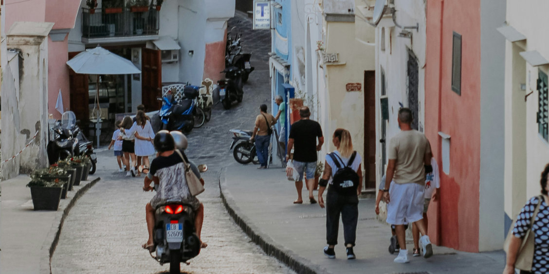 Circulation en scooter dans une rue étroite de Procida.