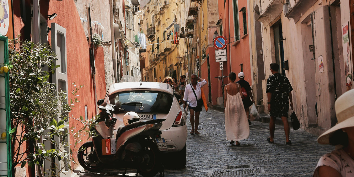 Une voiture circulant dans une ruelle colorée de Procida.