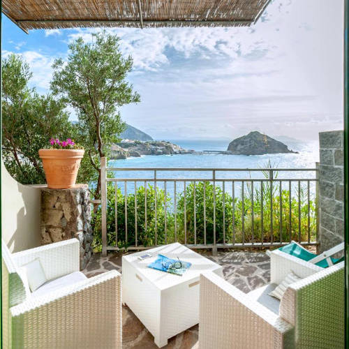 Terrasse privée avec mobilier de jardin offrant une vue imprenable sur le promontoire de Sant'Angelo.