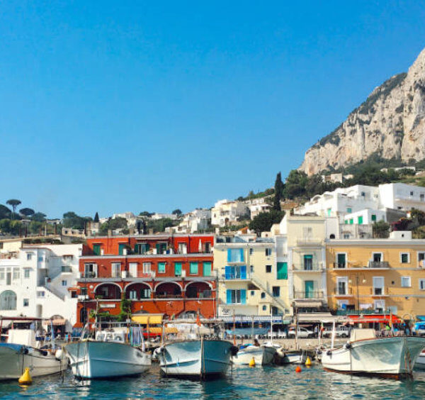 Bateaux de pêche et maisons colorées au port de Marina Grande à Capri, au pied des falaises.
