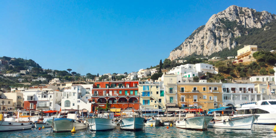 Bateaux de pêche et maisons colorées au port de Marina Grande à Capri, au pied des falaises.