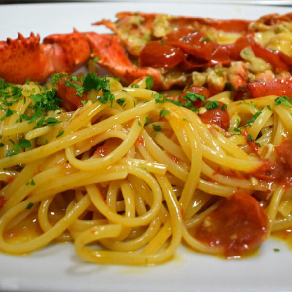 Assiette de pâtes au homard et tomates, spécialité culinaire de Procida.