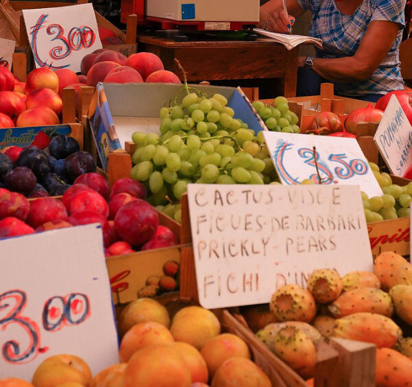 Marché de fruits à Sorrente avec raisins, pêches, figues de Barbarie et étals colorés.