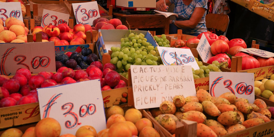 Marché de fruits à Sorrente avec raisins, pêches, figues de Barbarie et étals colorés.