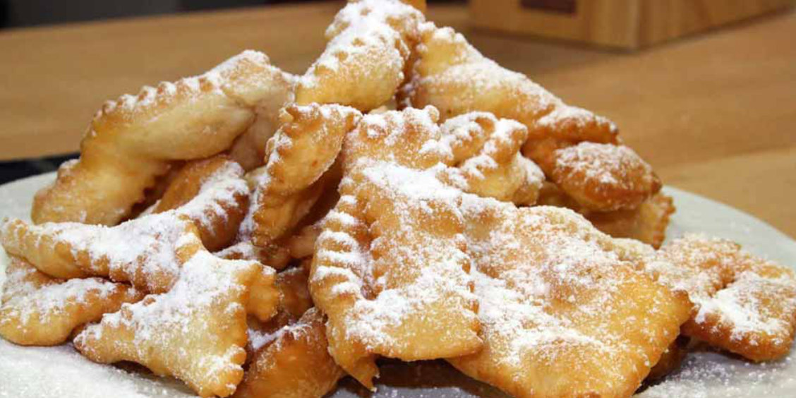 Beignets de carnaval de Sorrente saupoudrés de sucre glace sur une assiette.