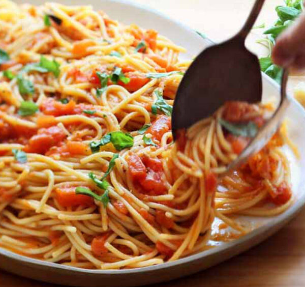Plat de spaghetti à la sauce tomate maison avec basilic et touche méditerranéenne.