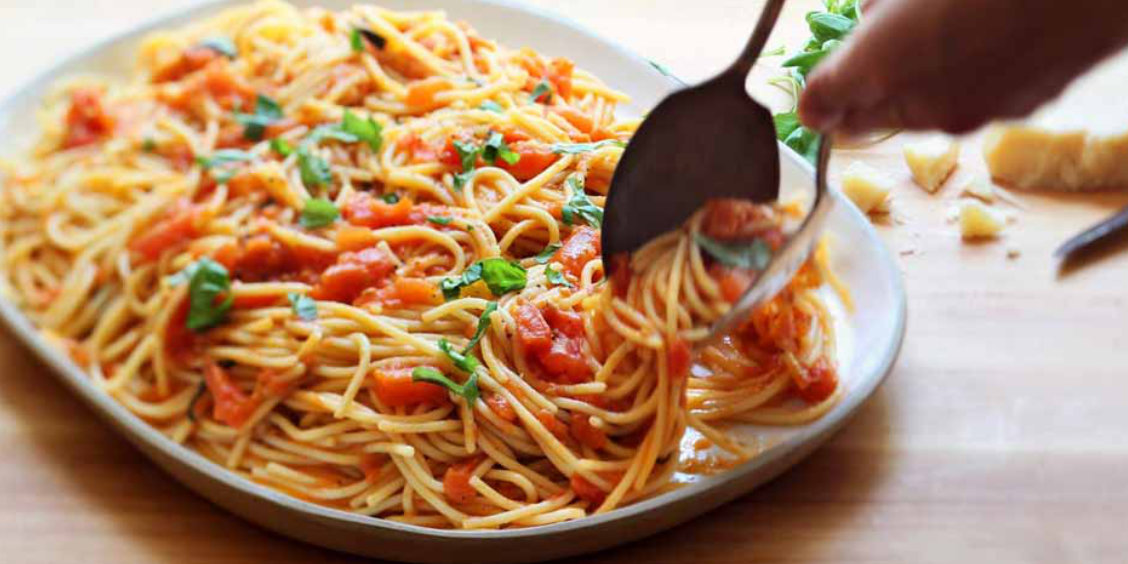 Plat de spaghetti à la sauce tomate maison avec basilic et touche méditerranéenne.