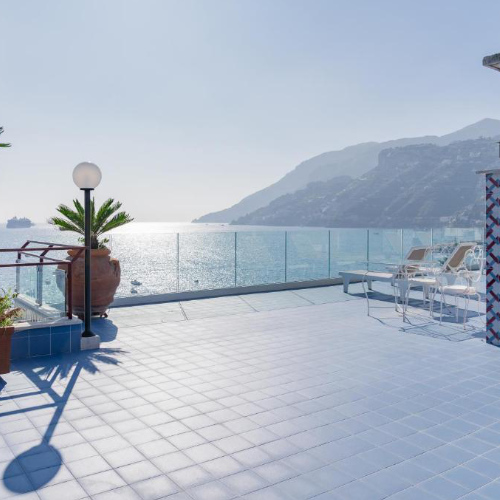 Terrasse carrelée de bleu avec vue panoramique sur la mer au Reginna Palace Hotel.