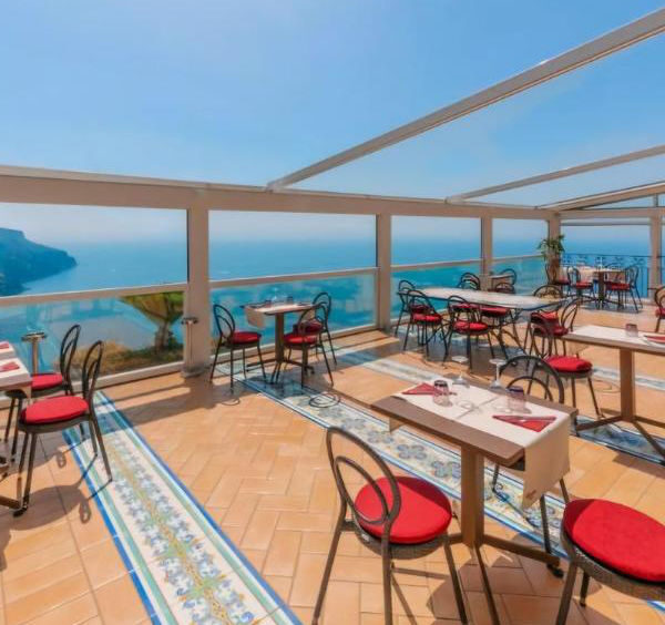Terrasse couverte d'un restaurant panoramique à Ravello offrant une vue spectaculaire sur la mer.