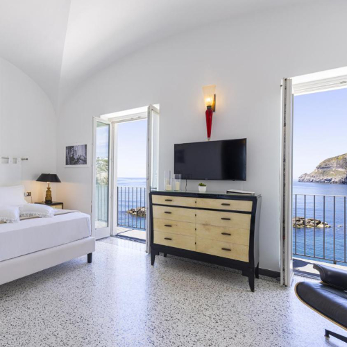 Chambre lumineuse au design moderne avec balcons ouvrant sur la mer.