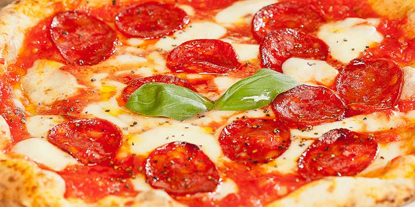 Pizza napolitaine au salami et mozzarella avec basilic, servie chez Rossopomodoro à Naples.