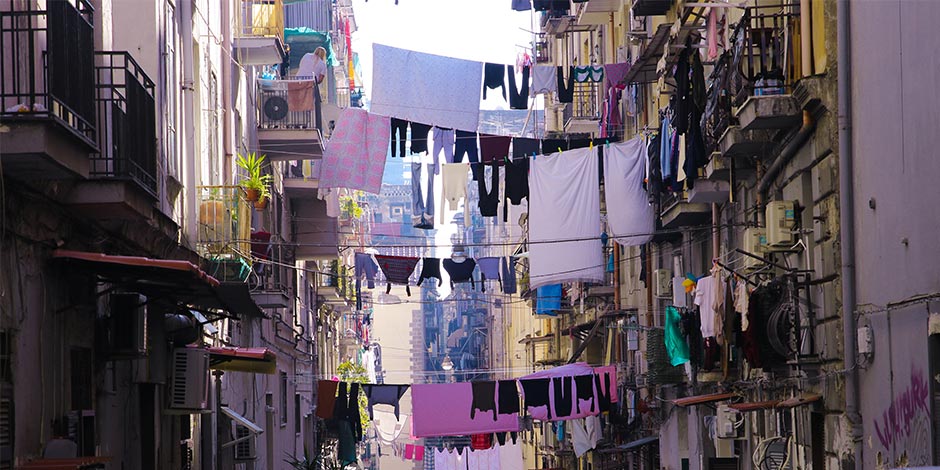 Ruelle du centre historique de Naples avec linge suspendu entre les immeubles et ambiance typique napolitaine.