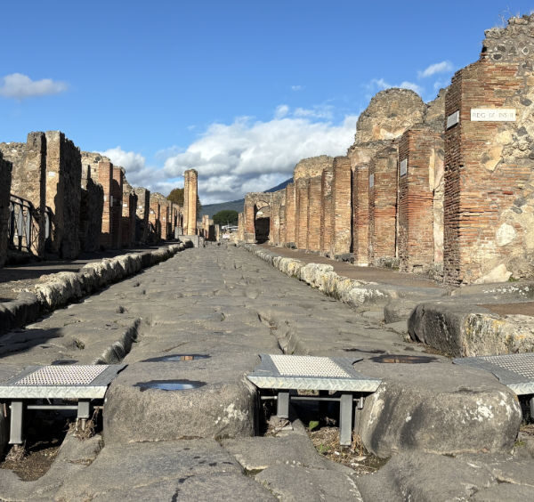 Rue pavée des ruines de Pompéi équipée de rampes d'accessibilité pour les personnes à mobilité réduite.