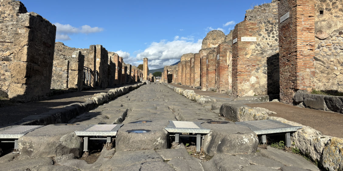 Rue pavée des ruines de Pompéi équipée de rampes d'accessibilité pour les personnes à mobilité réduite.