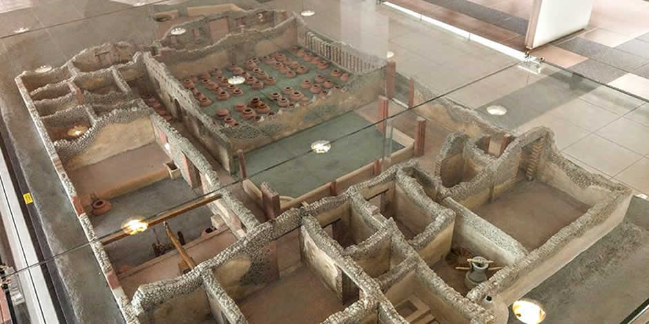 Maquette architecturale montrant la structure d'une ferme romaine antique avec ses différentes pièces.