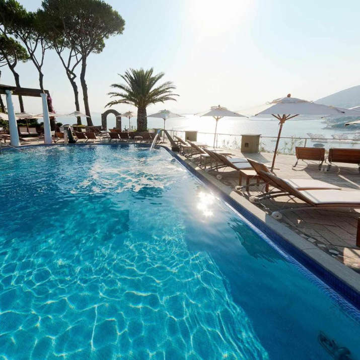 Piscine à débordement ensoleillée avec vue panoramique sur la côte au San Montano Resort & Spa.