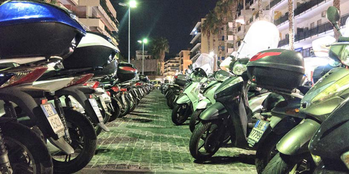 Scooters stationnés à Sorrente le soir dans une rue pavée près du centre.