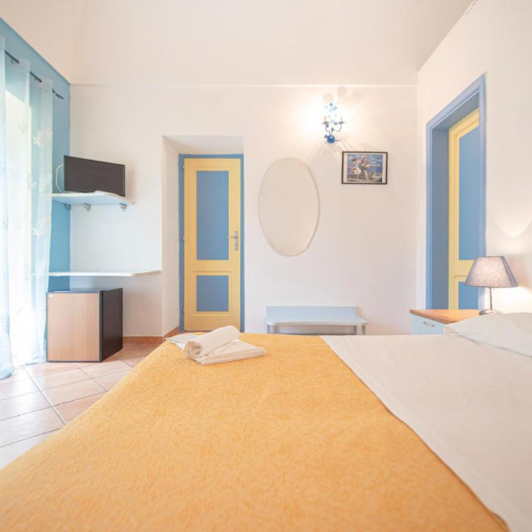 Chambre lumineuse à la décoration méditerranéenne déclinée dans des tons bleu et jaune.