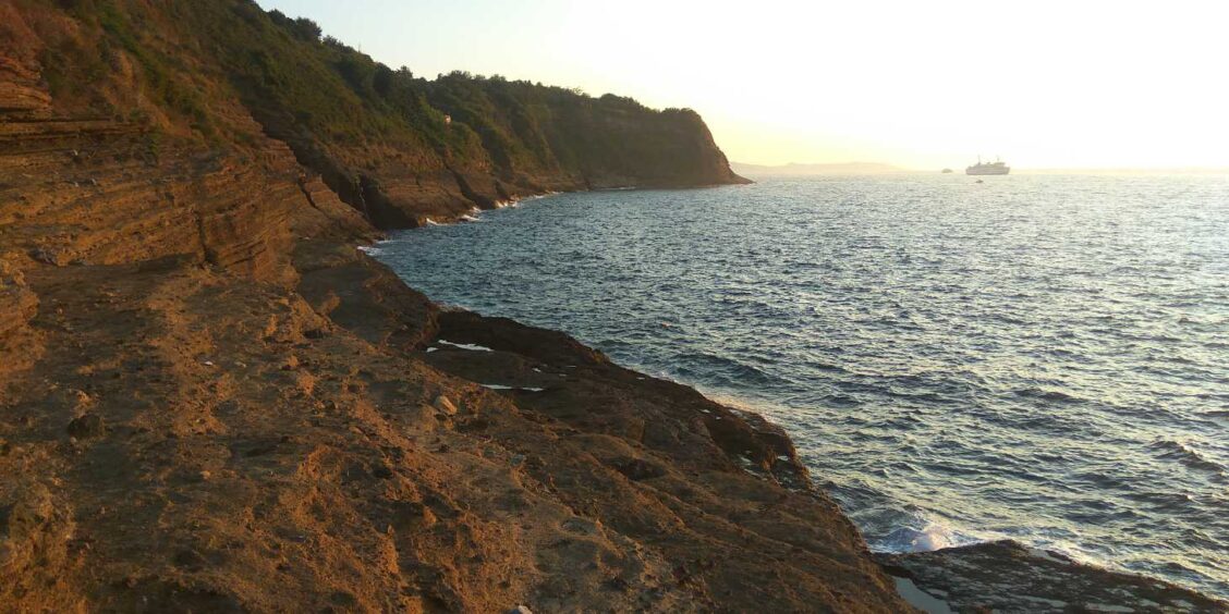 Falaises sauvages du promontoire de Solchiaro à Procida au coucher du soleil en Campanie.