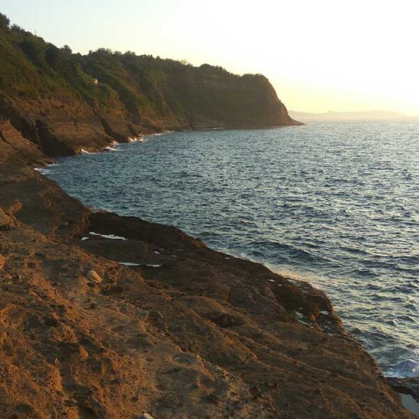 Falaises sauvages du promontoire de Solchiaro à Procida au coucher du soleil en Campanie.