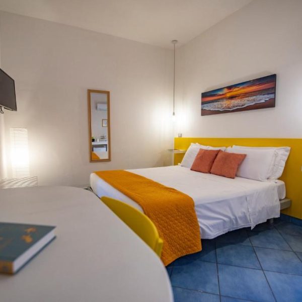Style moderne et couleurs solaires dans une chambre double du B&B Sonnino à Procida.