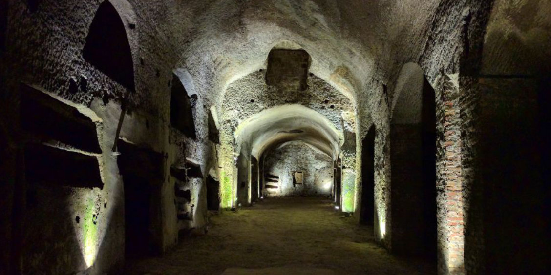 Souterrains de Naples avec galeries voûtées en pierre et passages historiques éclairés.