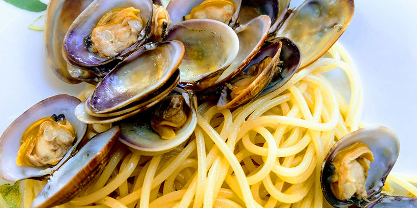 Assiette de spaghettis alle vongole (aux palourdes) avec persil frais et piment.