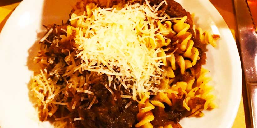 Pâtes au ragù napolitain avec sauce à la viande et fromage râpé, spécialité traditionnelle servie à Naples.