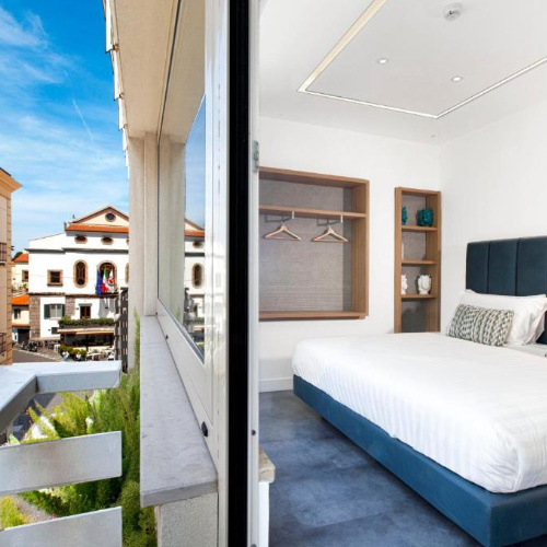 Chambre du Tasso Suites & Spa à Sorrente avec balcon donnant sur la ville.