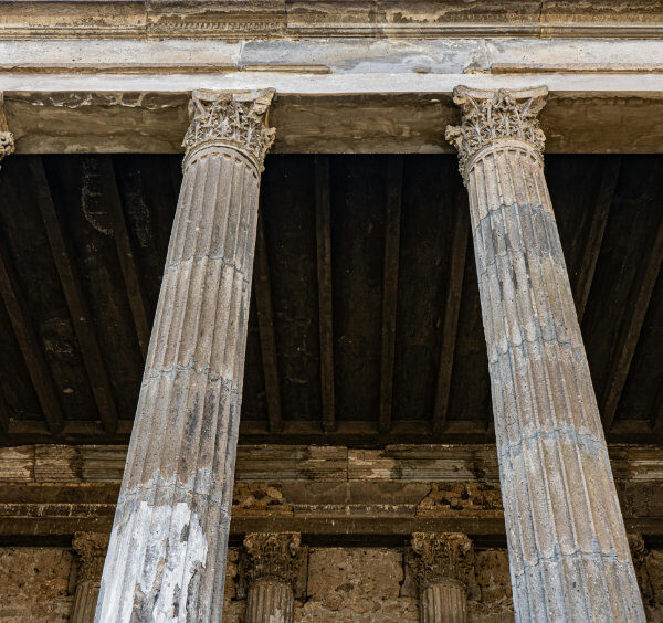 Série de colonnes corinthiennes flûtées supportant un entablablement dans un temple de Pompéi.