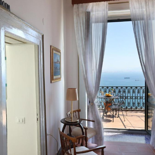 Vue de l'intérieur vers une terrasse ensoleillée dominant le golfe de Salerne.
