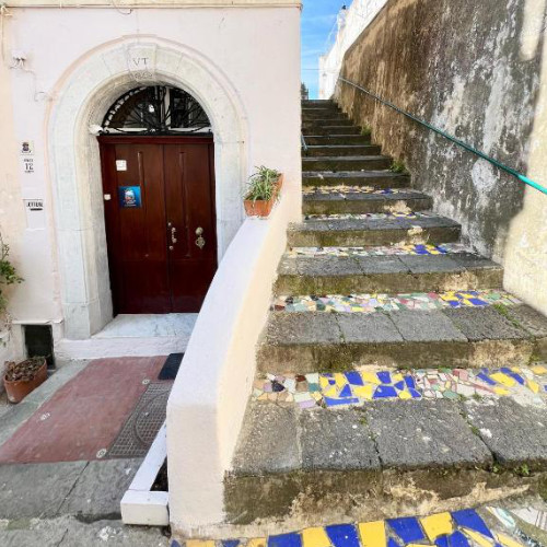 Escalier en pierre décoré de céramiques colorées devant une entrée typique à Vietri.