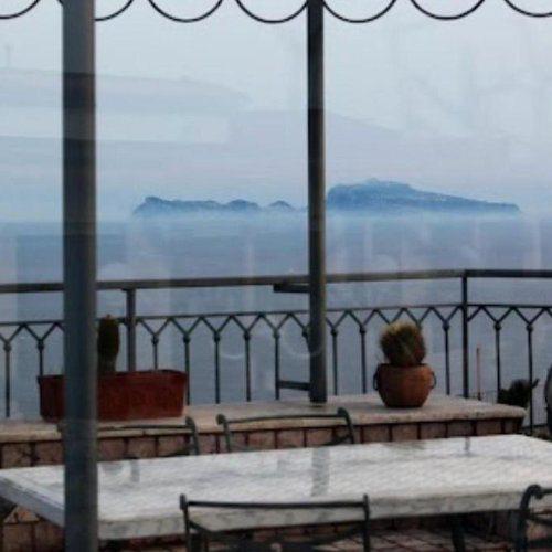 Silhouette de l'île de Capri vue depuis une terrasse surélevée à Naples par temps brumeux.