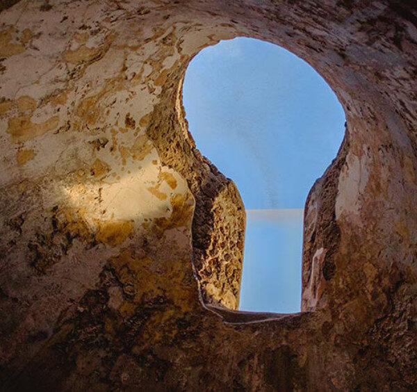 Oculus des thermes de Pompéi laissant apparaître le ciel bleu à travers une voûte antique.