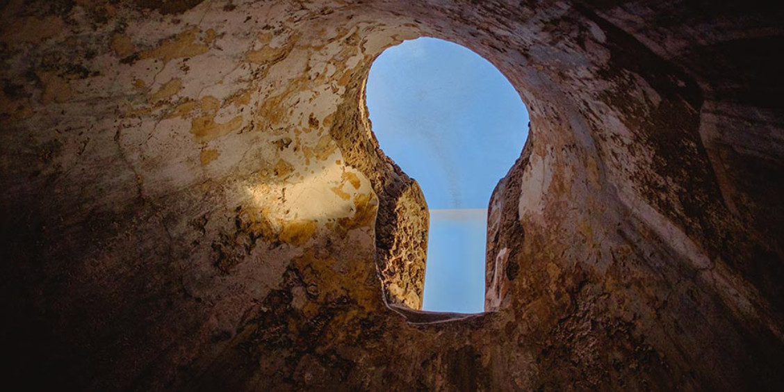 Oculus des thermes de Pompéi laissant apparaître le ciel bleu à travers une voûte antique.